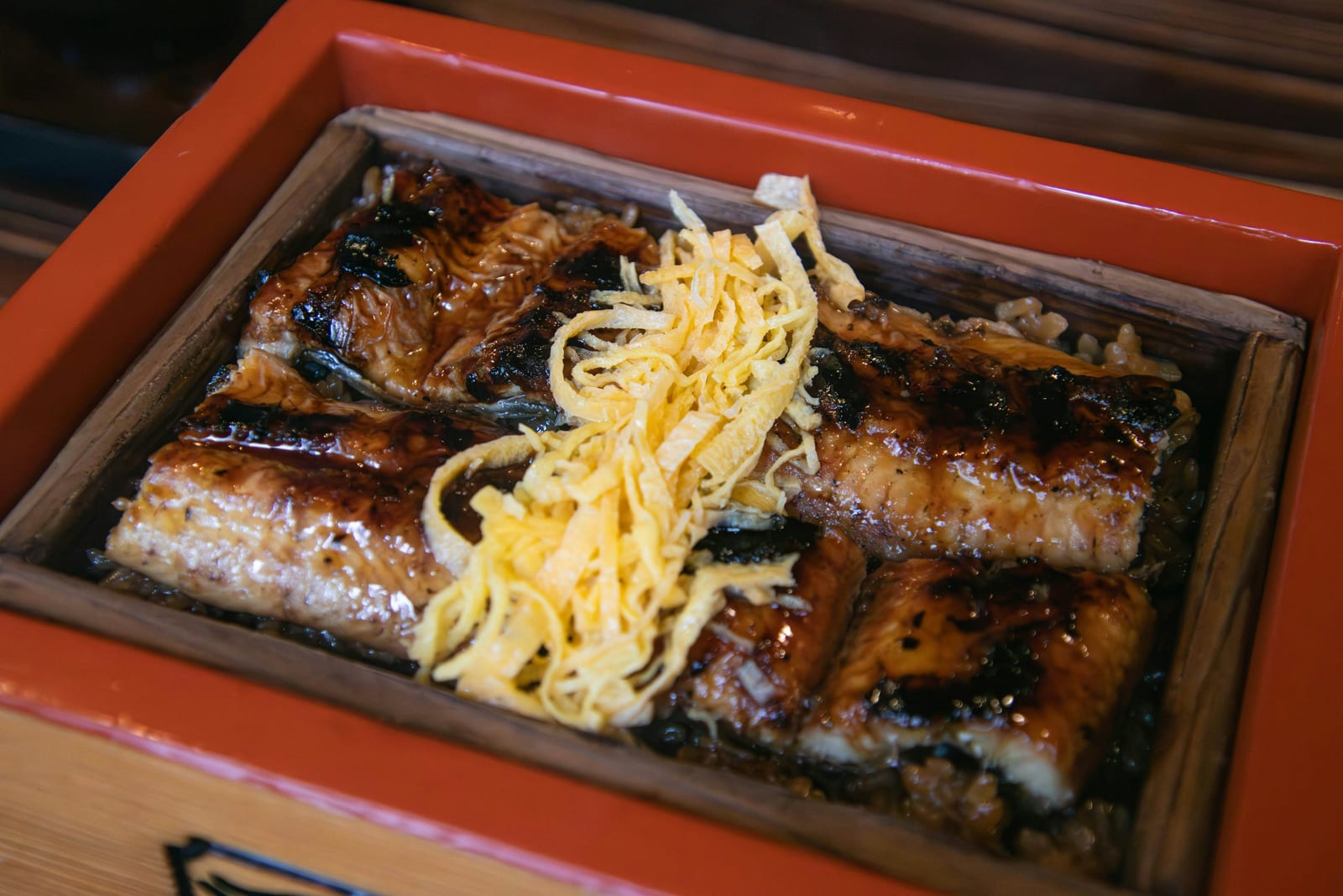 Grilled eel over rice topped with shredded omelette in a lacquer box.