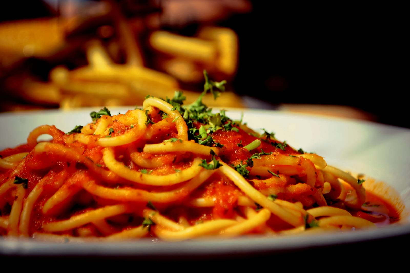 A plate of bucatini in a rich red tomato and guanciale sauce, the Roman amatriciana.