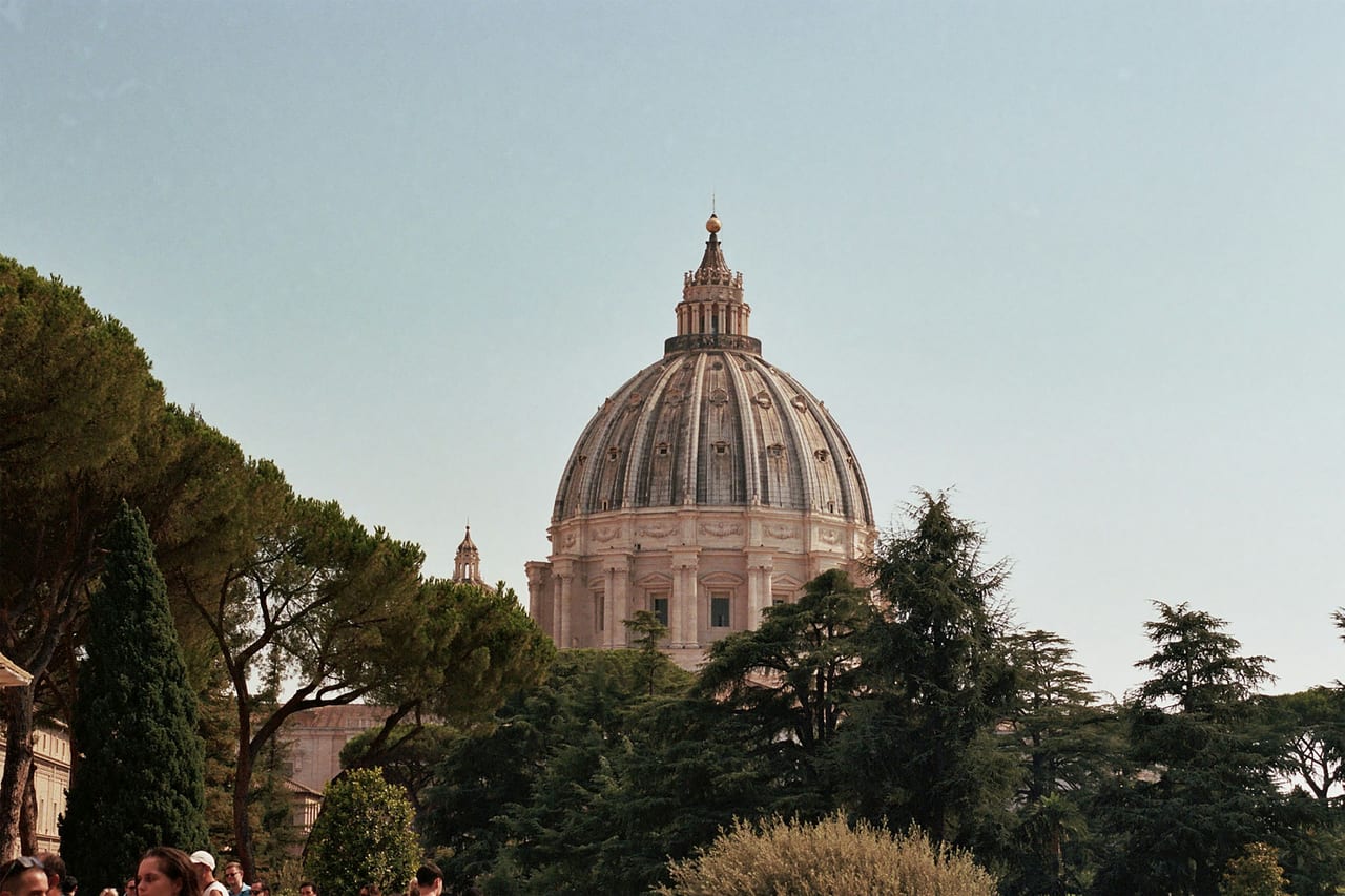 St Peter's dome sits framed at the end of a hedge-lined avenue, seen through the Aventine keyhole.