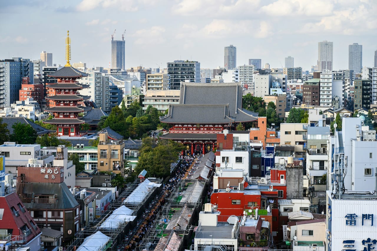 The five-story pagoda and Hozomon gate of Senso-ji rise against a bright blue sky in Asakusa.