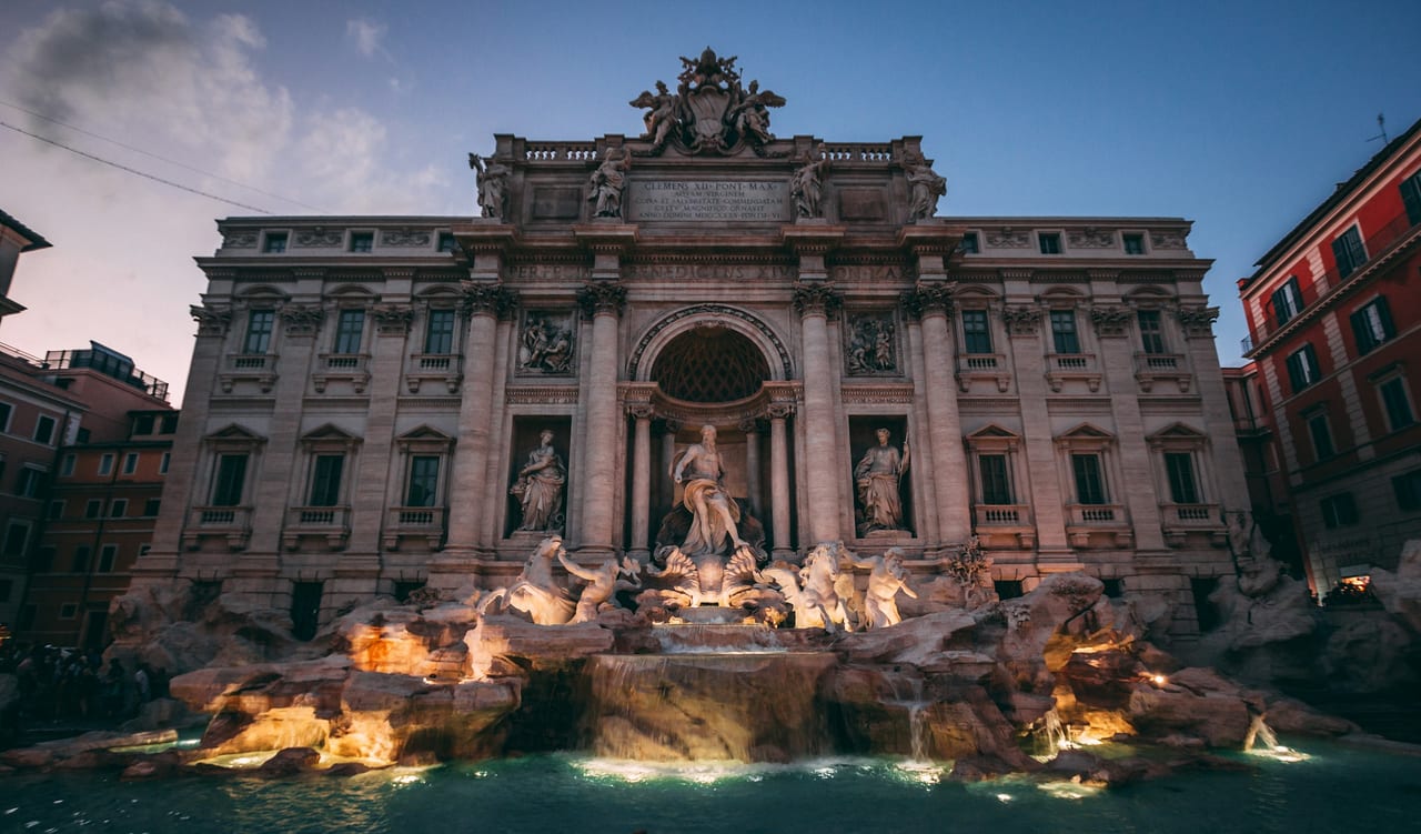 The Trevi Fountain's tritons and sea horses spill into its turquoise basin below the palace facade.