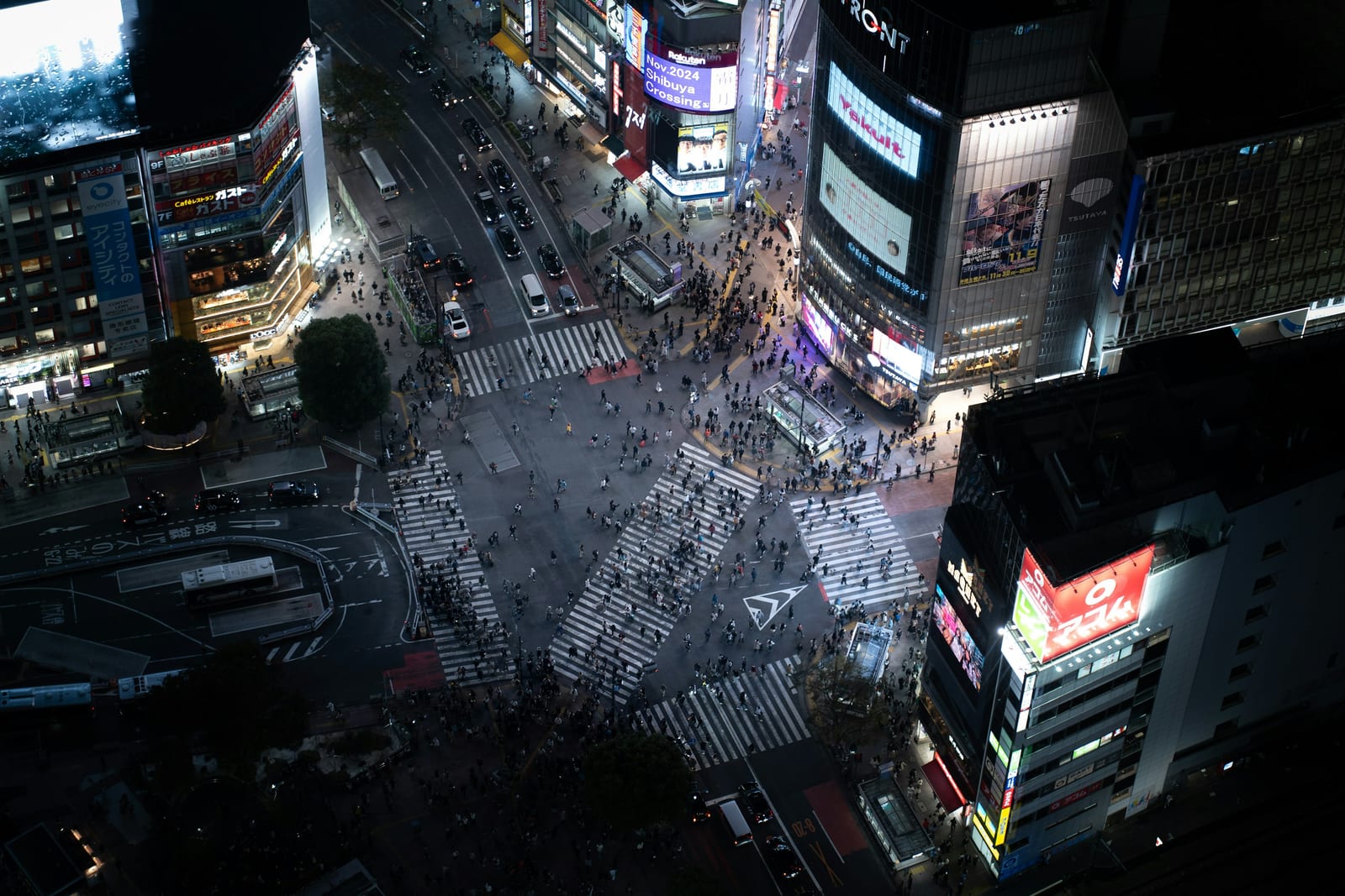 Shibuya Crossing lit up at night from above