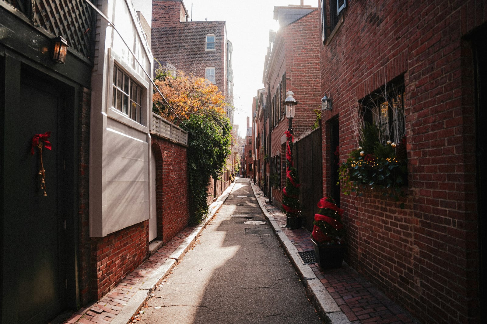 Narrow street in Boston's North End with brick buildings and restaurant awnings