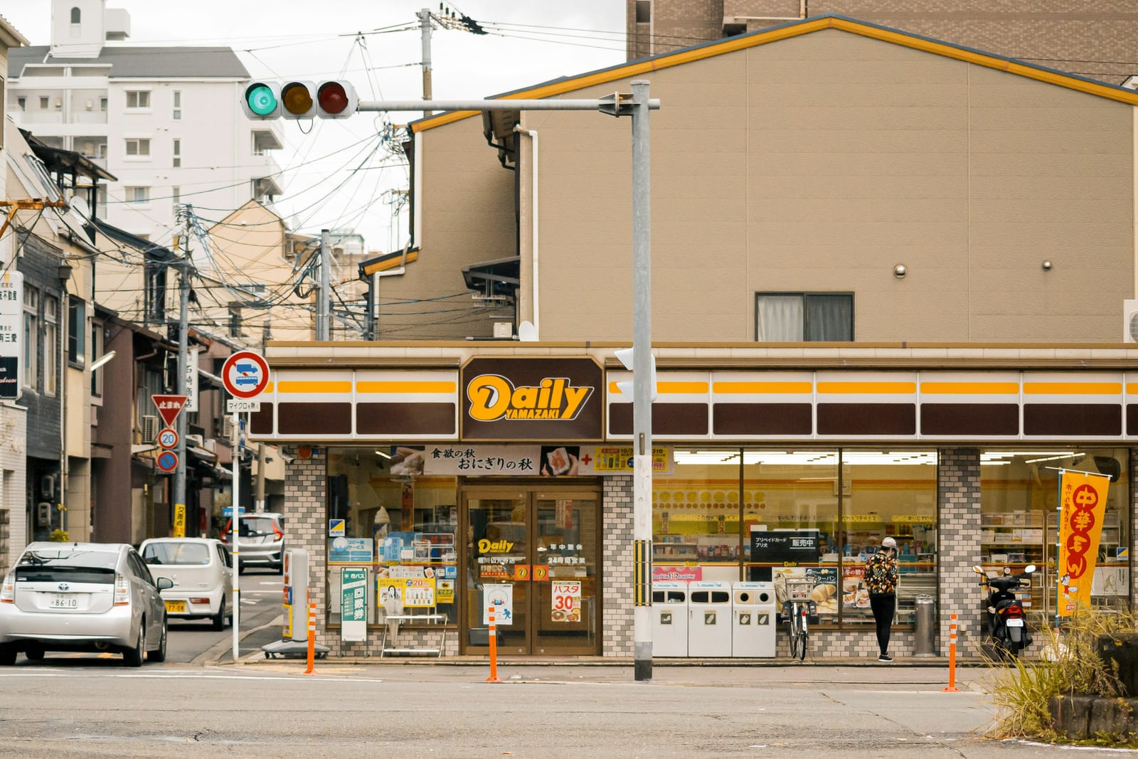 A brightly lit Japanese convenience store on a Tokyo street corner.