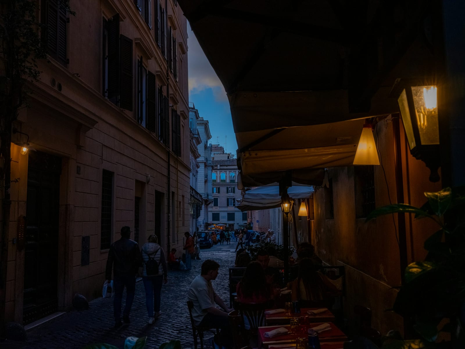 The red-and-white outdoor tables of Trattoria Da Enzo al 29 on a Trastevere lane.