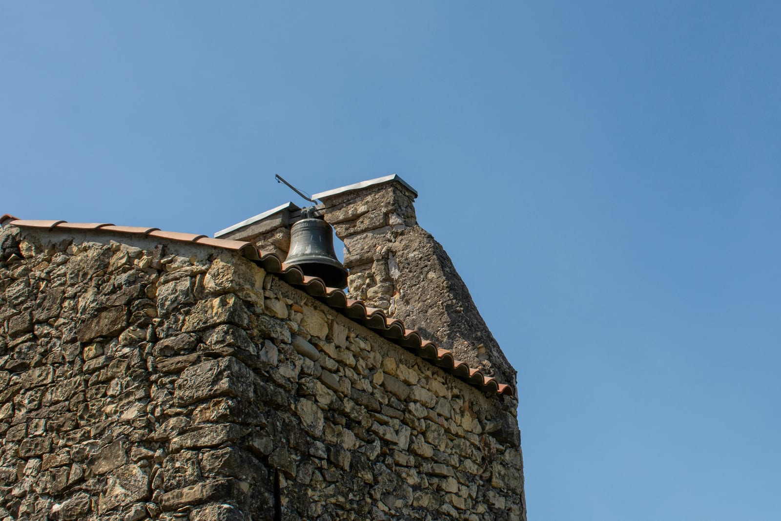 A medieval bell tower rising beside a stone church on the Aventine Hill.