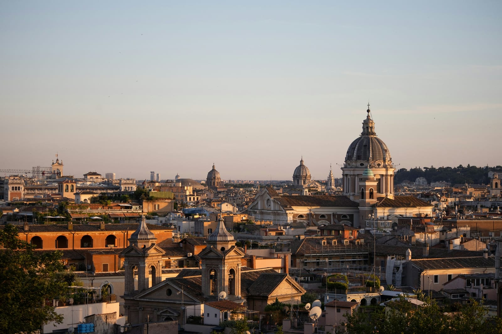Rome's sea of domes and bell towers stretching to the horizon in golden evening light.