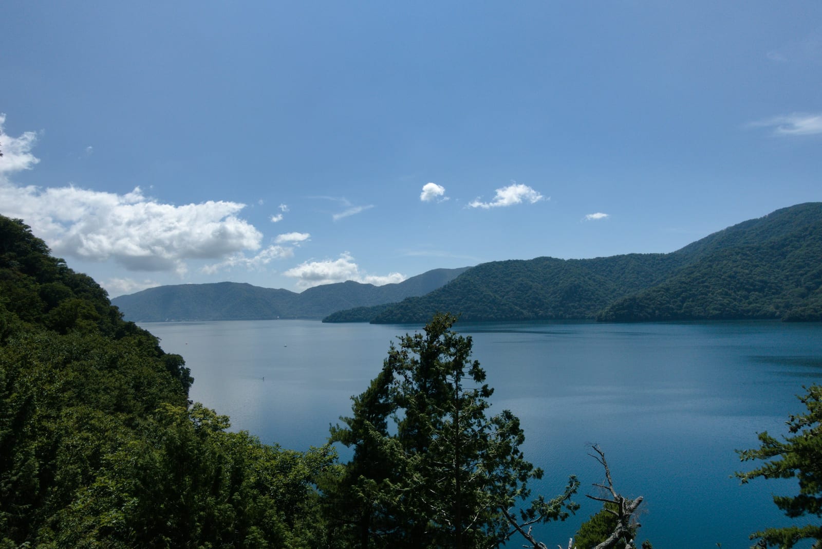 Serene blue Lake Chuzenji ringed by green mountains above Nikko.