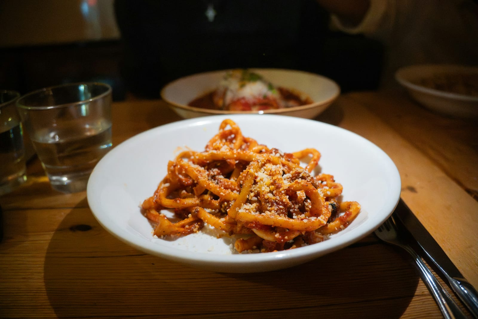 A plate of fresh pasta with tomato sauce and basil at an Italian restaurant.