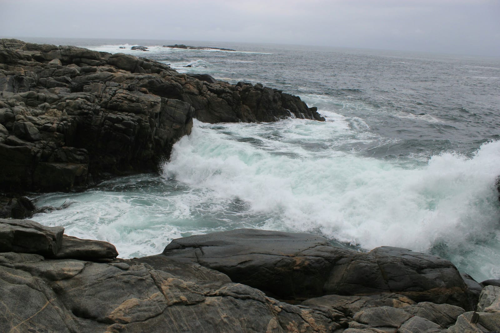 Rocky New England coastline with waves crashing against granite.