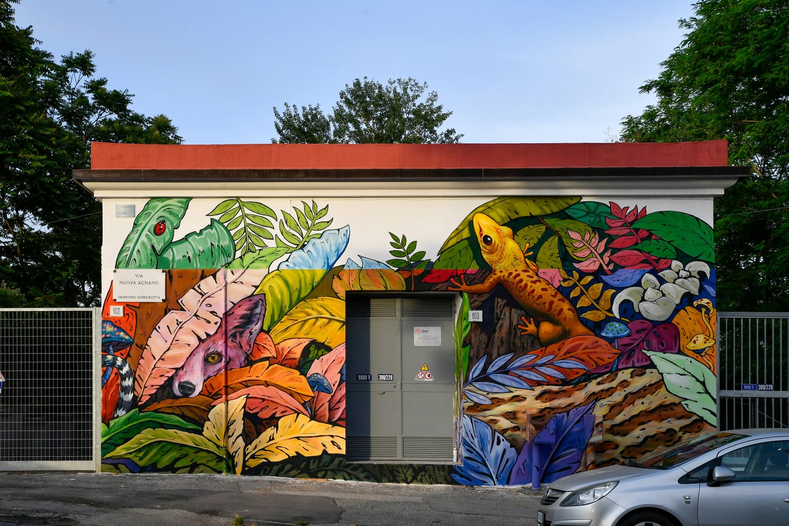 A large painted mural covering a building wall in a Roman neighborhood.