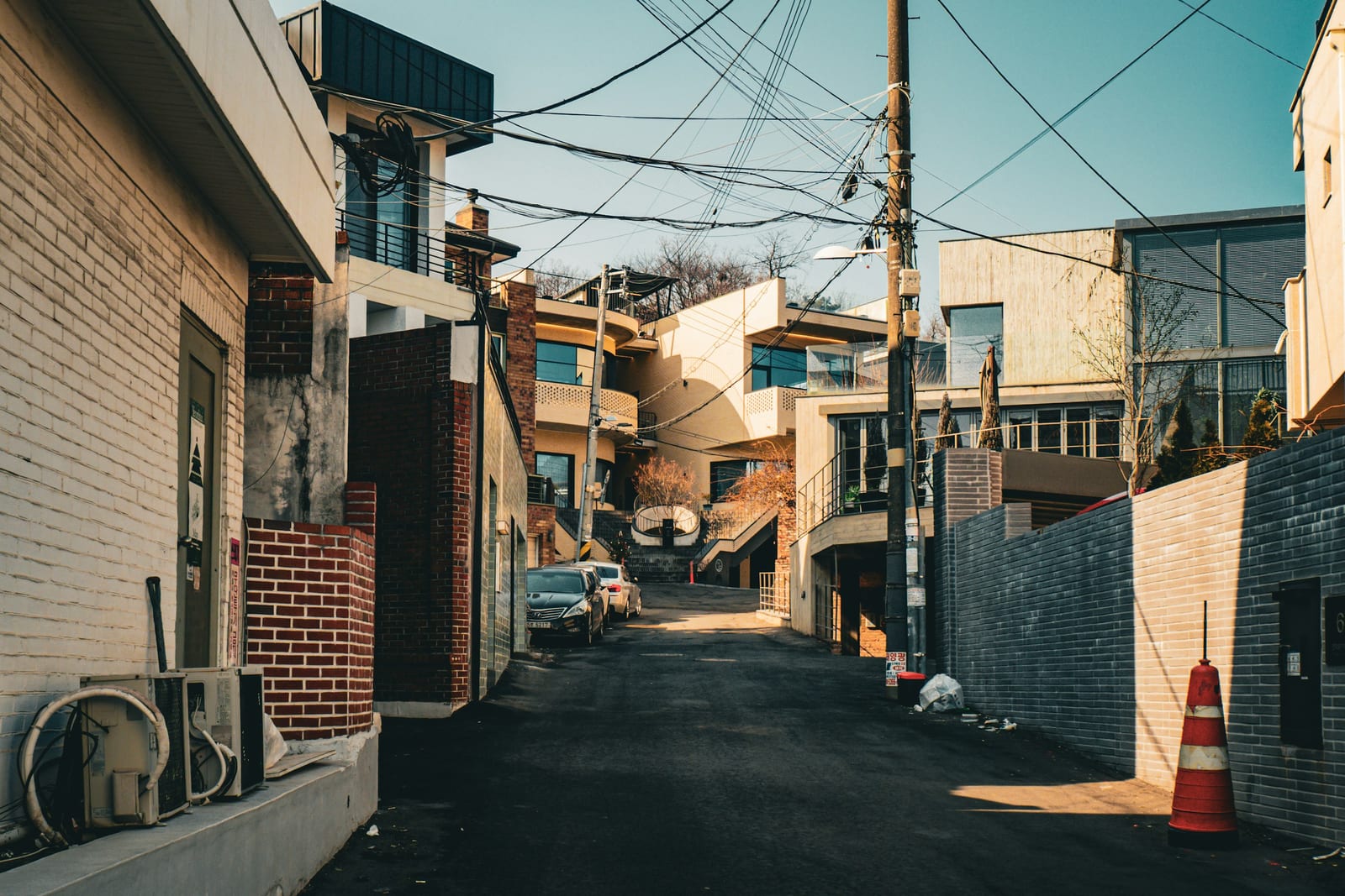 Narrow street between buildings with power lines overhead
