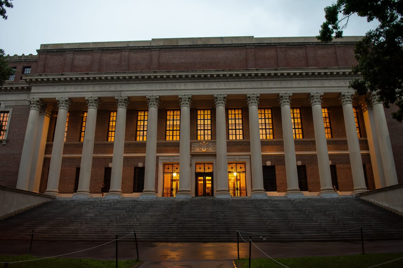 Harvard Yard's red-brick dormitories and green lawns frame the path to Widener Library on a fall morning.