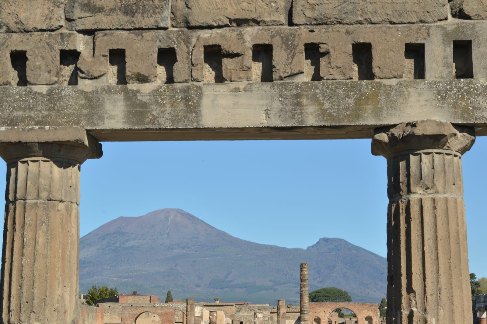 The ruins of Pompeii's forum with Mount Vesuvius rising behind them.
