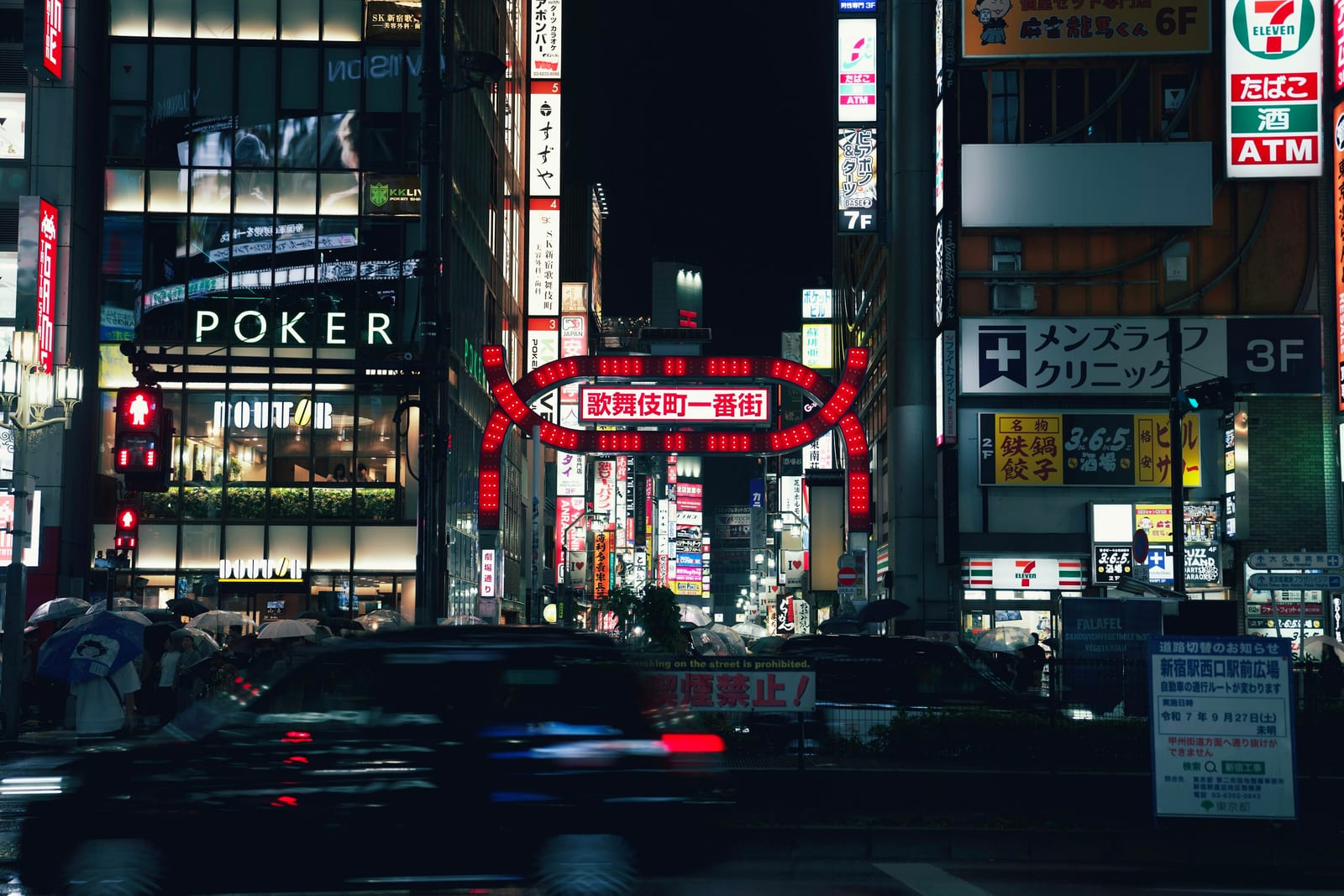 The red Kabukicho Ichibangai gate glowing over the entertainment district at night.