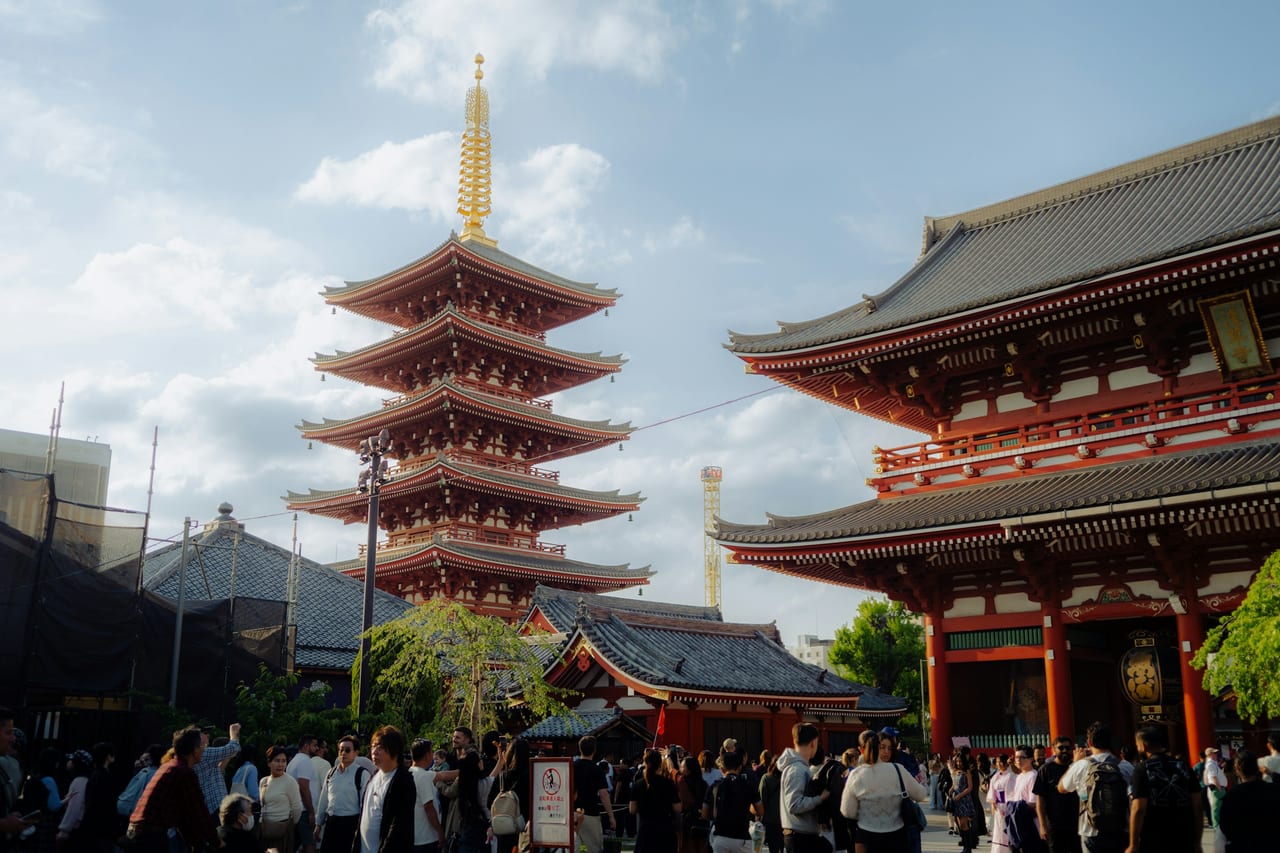 The five-story pagoda and Hozomon gate of Senso-ji rise against a bright blue sky in Asakusa.