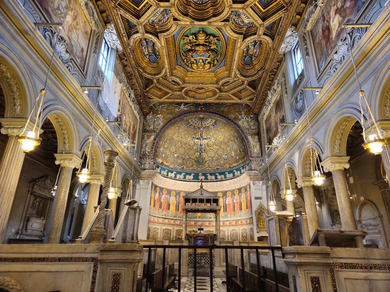 San Clemente's gilded 12th-century apse mosaic of the Cross glows above the frescoed altar of the upper basilica.