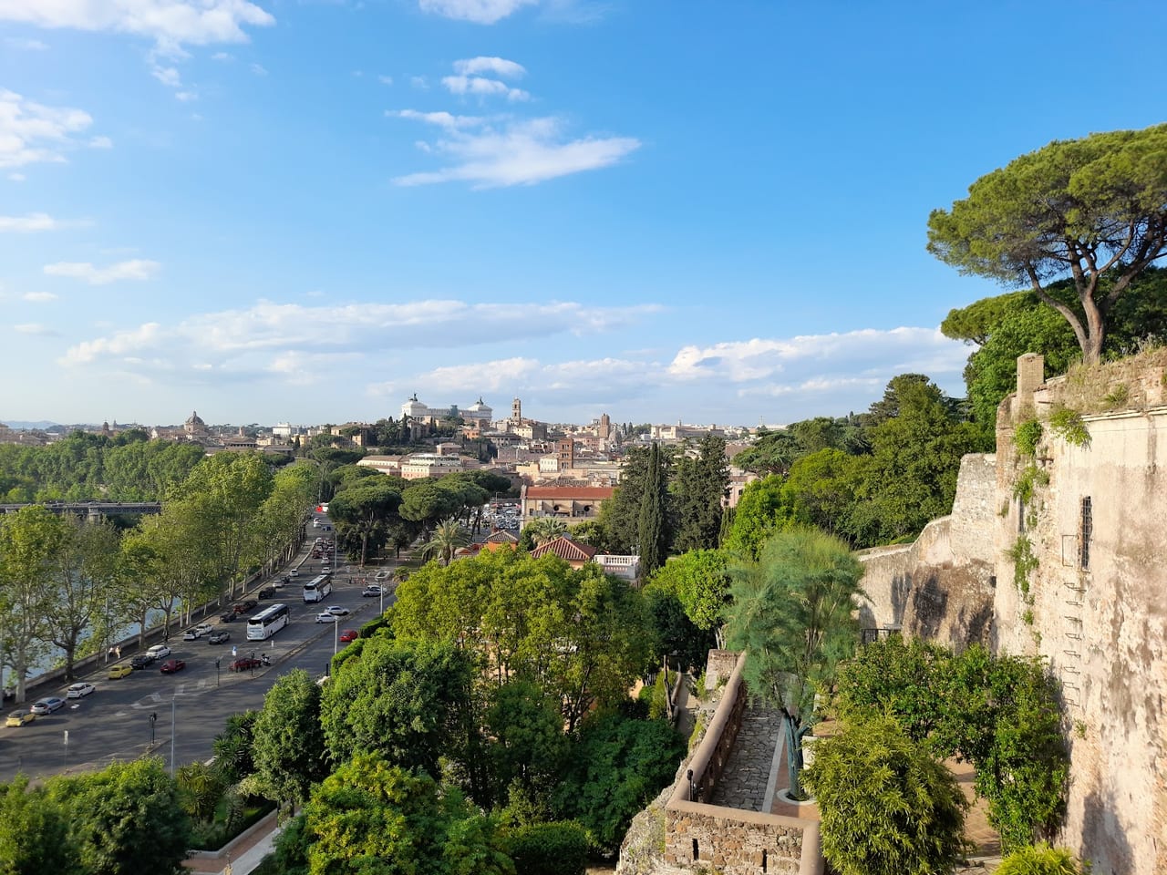 From the Orange Garden terrace on the Aventine, the rooftops of Rome and the Vittoriano spread across the river under a bright sky.