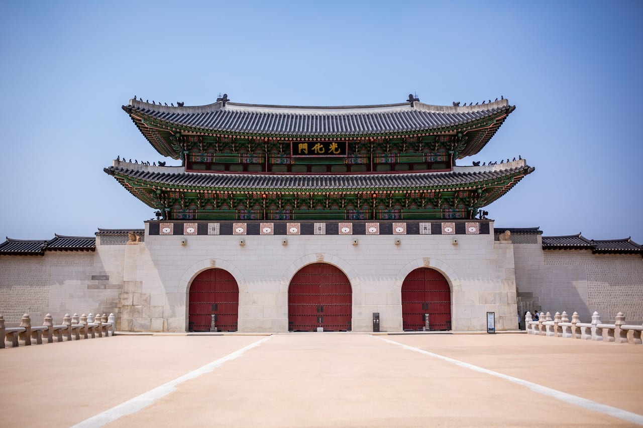 Gyeongbokgung Palace's main gate stands against a clear blue sky in Seoul.