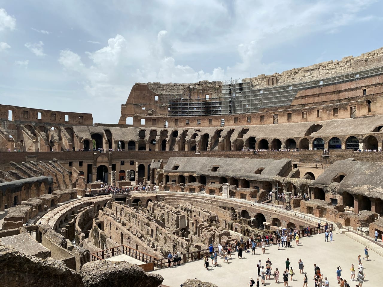 Inside the Colosseum, tiers of stone seating ring the exposed passages beneath the arena floor.